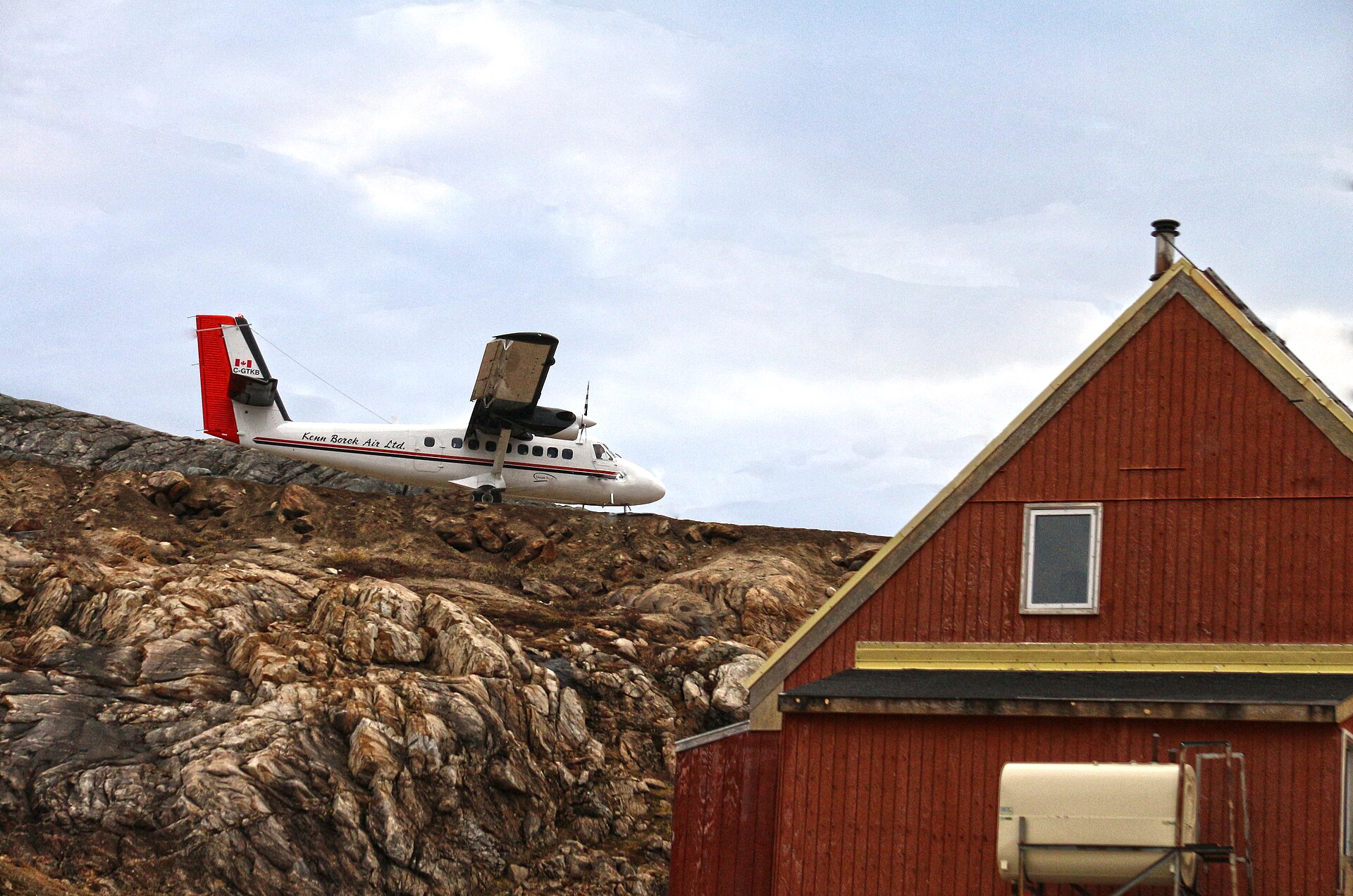 A twin-engine Twin Otter aircraft on short final to a gravel runway in Kimmirut, Nunavut